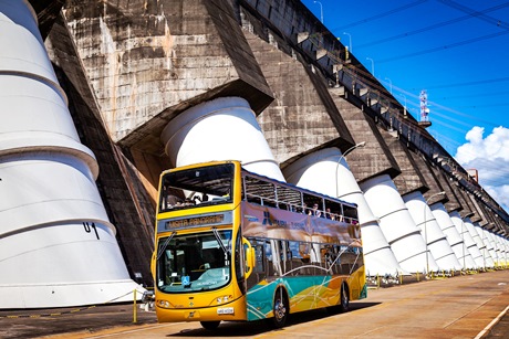 Ônibus de turismo passa diante da barragem da Itaipu. Foto: Rubens Fraulini/Itaipu Binacional